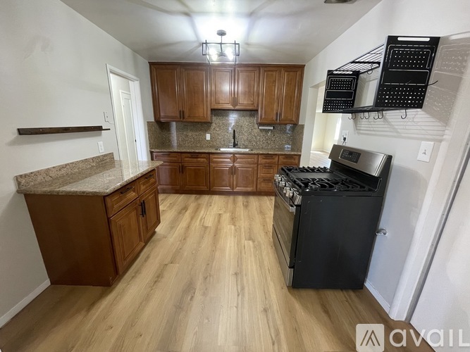 A kitchen with wooden cabinets and a black stove top oven.