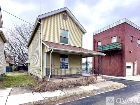 A house with a red brick building in the background.