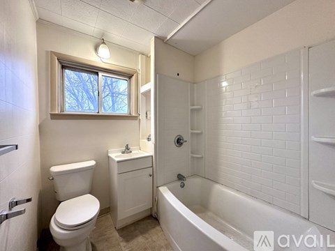 A white bathroom with a toilet, sink, and bathtub.
