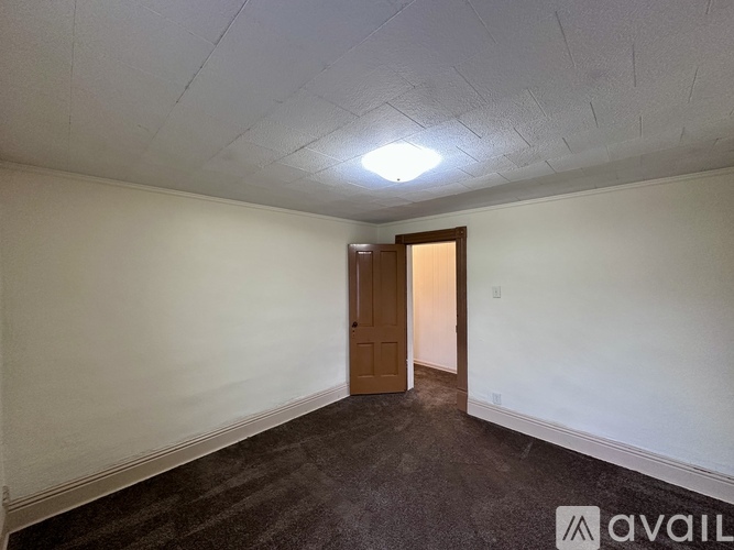 A room with a carpeted floor and a door.