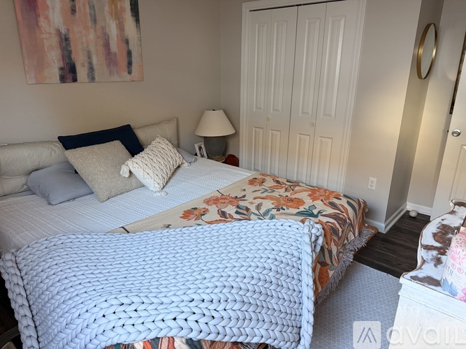A bedroom with two beds and a painting on the wall.
