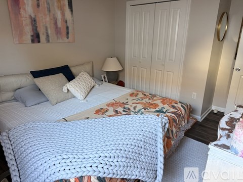 A bedroom with two beds and a painting on the wall.