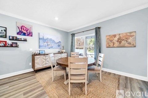 A dining room with a wooden table and chairs.