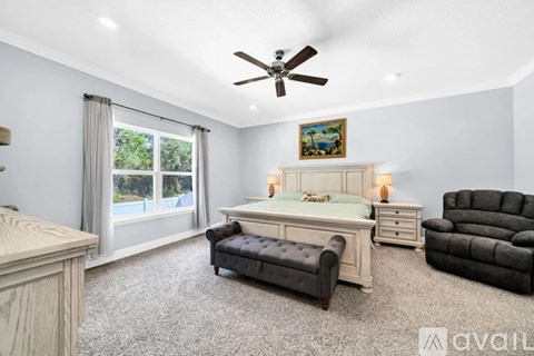 A bedroom with a bed, chair, and a painting on the wall.