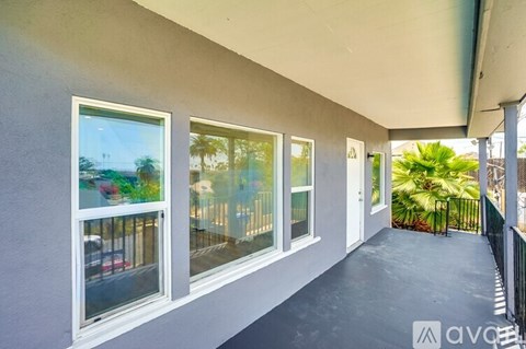 A balcony with a view of a street and palm trees.