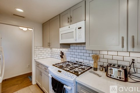 A kitchen with a white stove top oven and a white microwave above it.