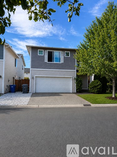 A house with a garage and a driveway in front of it.