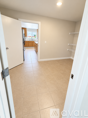 A white door is open to a kitchen.