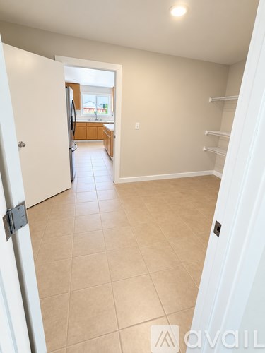A white door is open to a kitchen.
