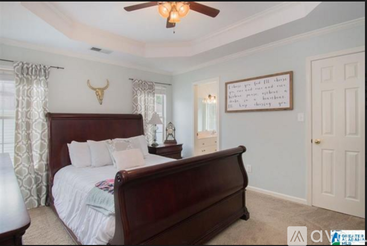 A bedroom with a large bed and a ceiling fan.