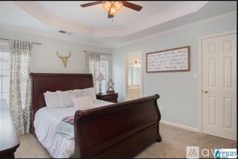 A bedroom with a large bed and a ceiling fan.