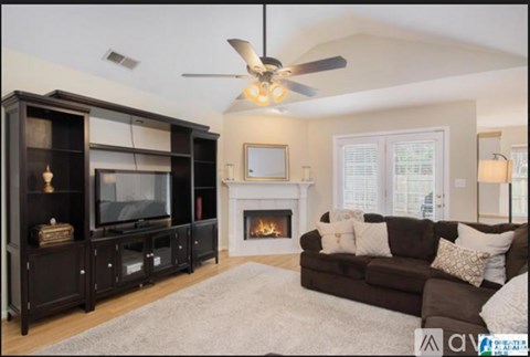 A living room with a fireplace and a television.