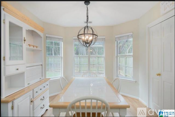 A dining room with a wooden table and chairs.