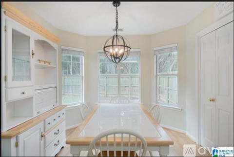 A dining room with a wooden table and chairs.
