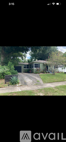A house with a driveway and trees in the background.