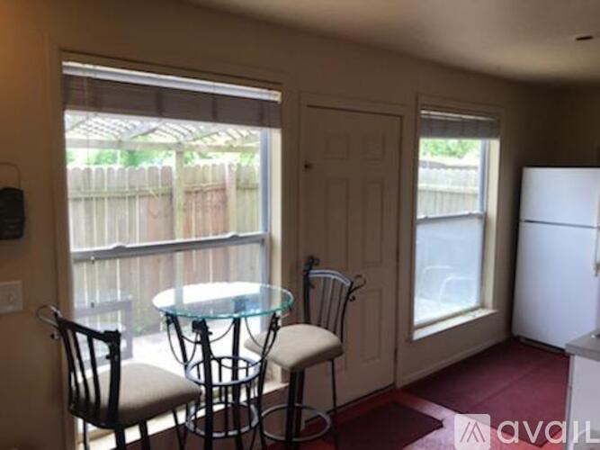 A dining room with a glass table and chairs.
