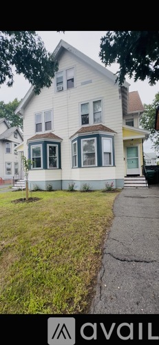 A two-story house with a white exterior and a green door.