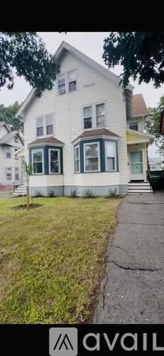 A two-story house with a white exterior and a green door.