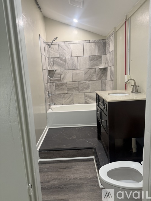 A bathroom with a toilet, sink, and shower area.