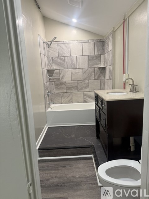 A bathroom with a toilet, sink, and shower area.