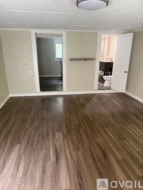 A room with wooden flooring and a white ceiling.