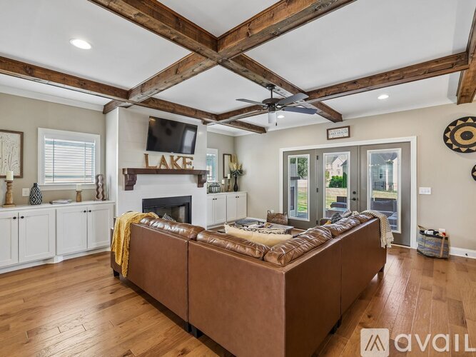 A living room with a brown couch and a fireplace.
