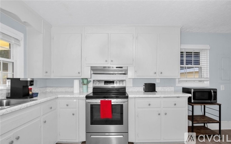 A kitchen with white cabinets and a stainless steel oven.