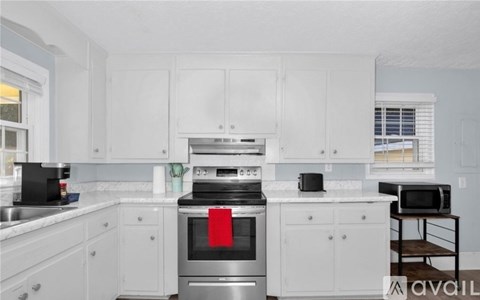 A kitchen with white cabinets and a stainless steel oven.