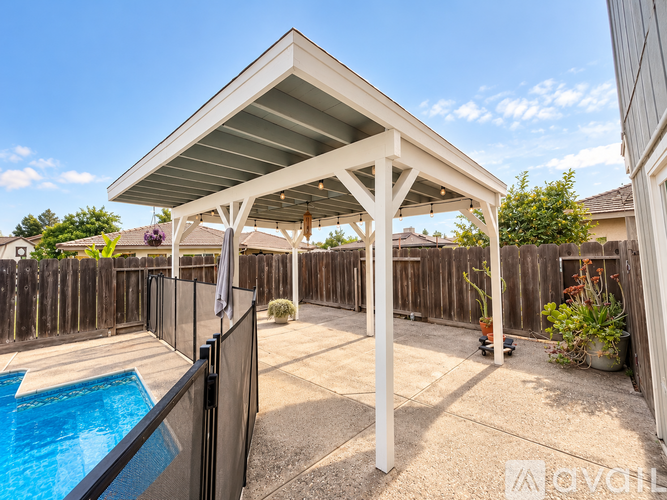 A pool under a white roofed structure.