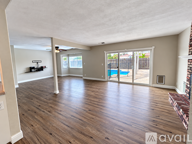A living room with a pool visible through the sliding glass doors.