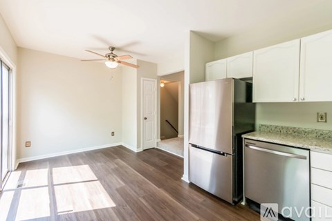 A kitchen with a refrigerator and stove top oven.