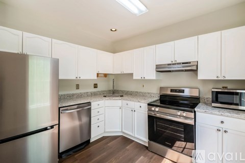 A kitchen with white cabinets and stainless steel appliances.