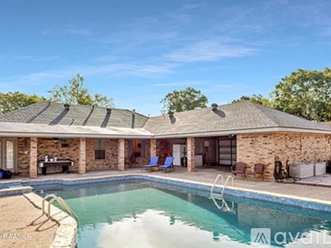 A house with a pool in front of it.
