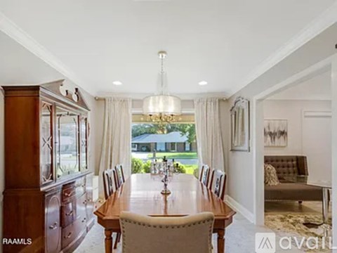 A dining room with a wooden table and chairs.
