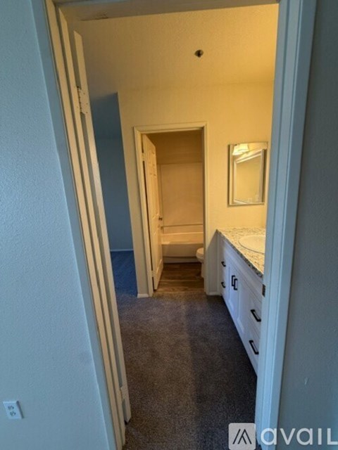 A bedroom with a bed, dresser and mirror.