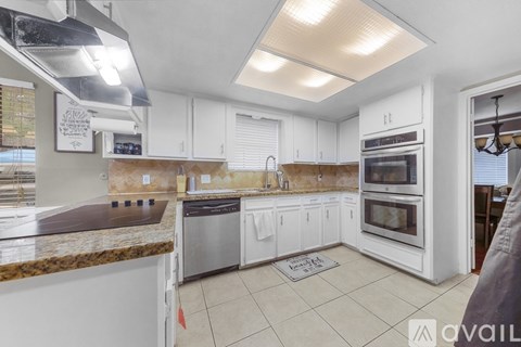 A kitchen with white cabinets and a granite countertop.