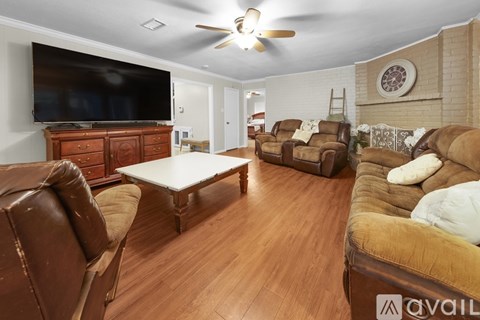 A living room with brown leather furniture and a flat screen TV.