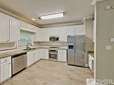 A kitchen with white cabinets and stainless steel appliances.
