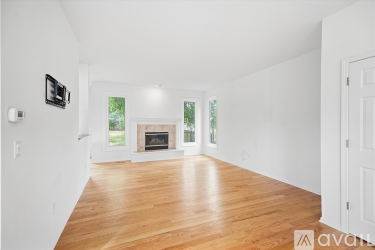 A spacious living room with a fireplace and wooden floors.
