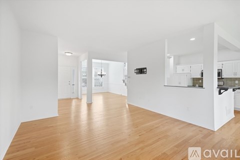 A spacious room with wooden floors and white walls.
