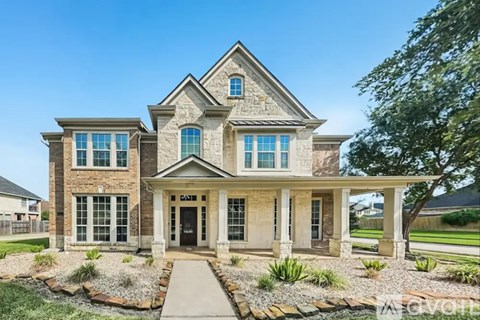 A large, two-story house with a front porch and multiple windows.