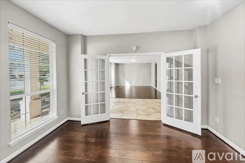 A room with a wooden floor and a large open door.