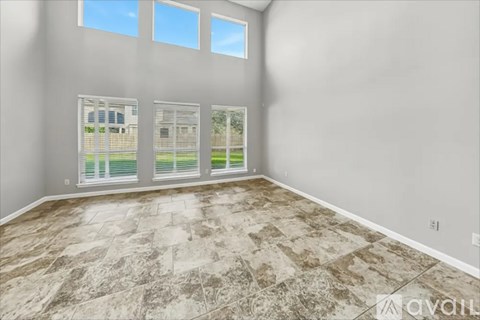 A room with a marble floor and three windows.