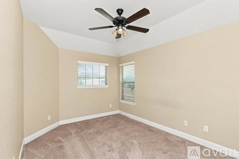 A room with a ceiling fan and a window with blinds.