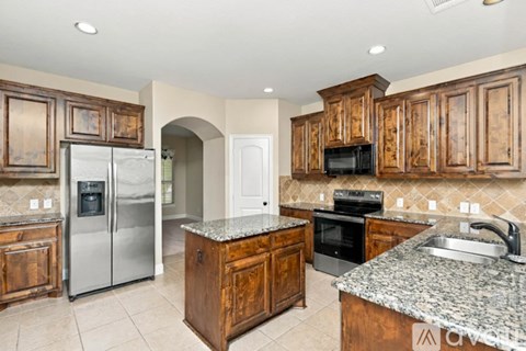 A kitchen with wooden cabinets and granite countertops.