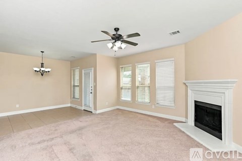 A living room with a fireplace and a ceiling fan.