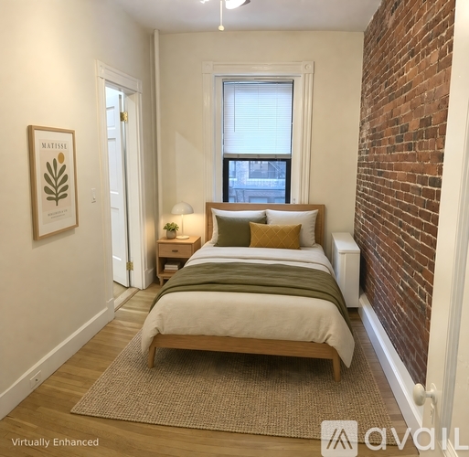 A bedroom with a bed, nightstand, and window.