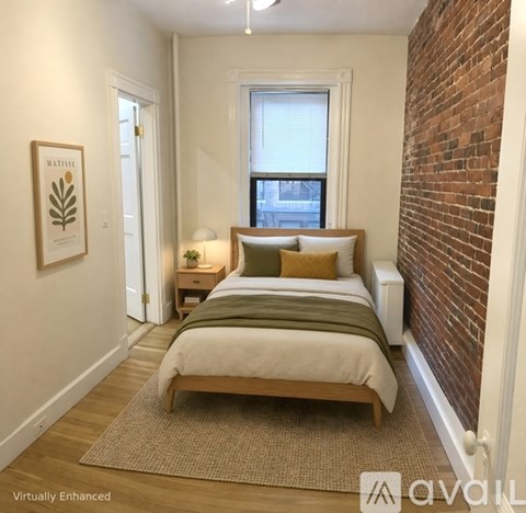 A bedroom with a bed, nightstand, and window.
