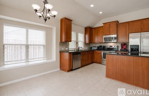 A kitchen with wooden cabinets and a range hood.