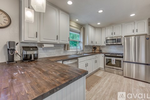 A kitchen with white cabinets and a wooden countertop.